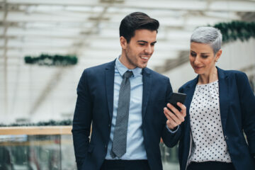 Young Professionals schauen gemeinsam auf Handy