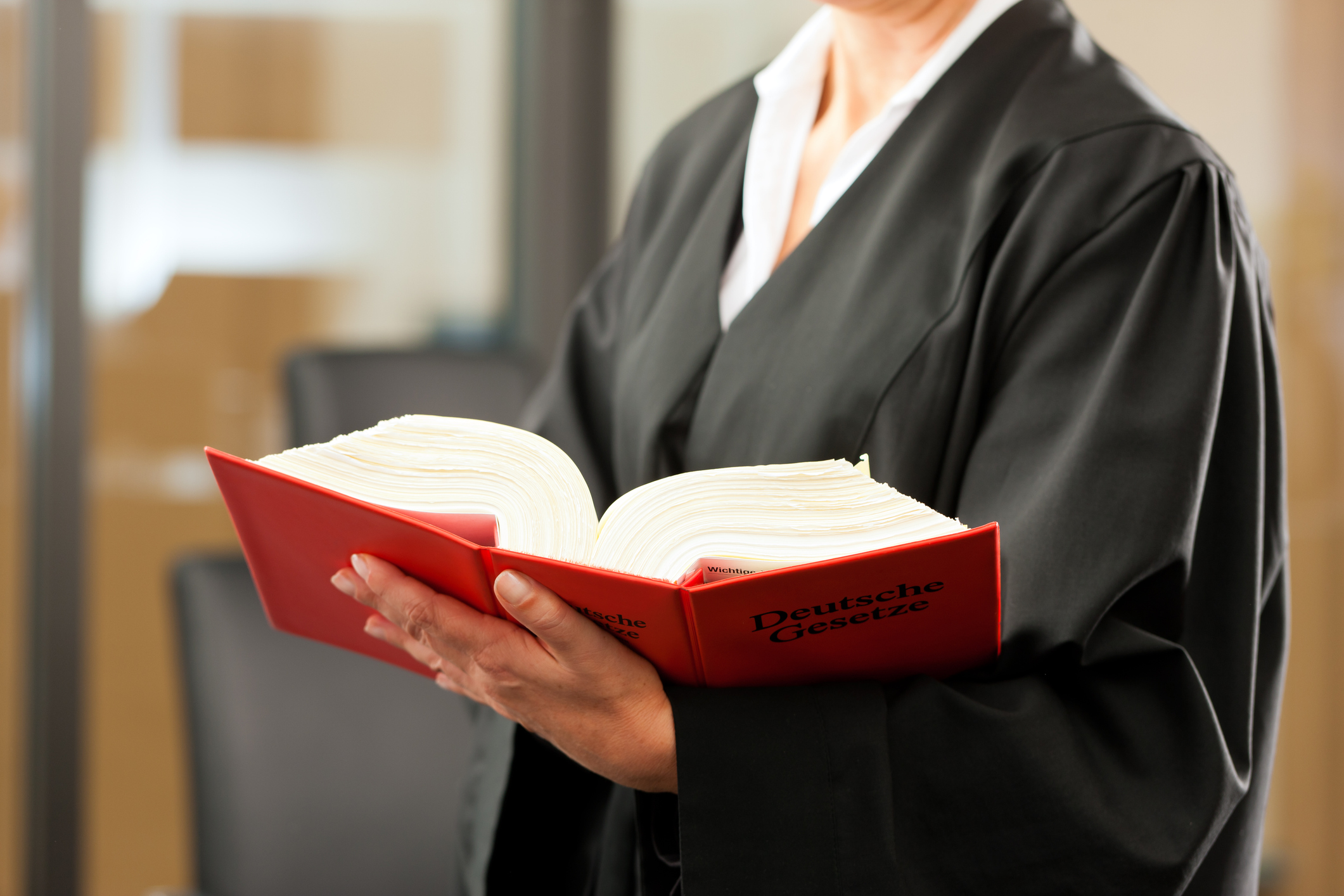 Juristin in Robe mit Gesetzbuch in der Hand