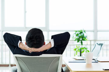 Rear view of young asian businessman leaning back on chair at office, taking a break at work